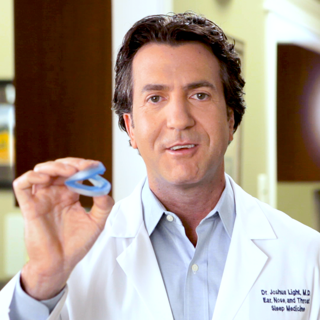 image of ENT doctor and sleep specialist holding the ZQuiet mouthpiece with an expression of approval