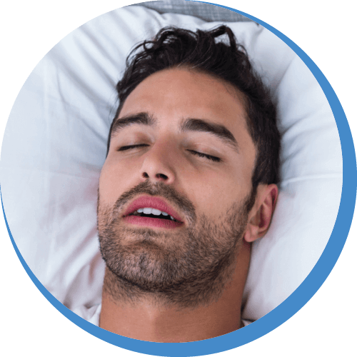a close up of man's face snoring with mouth open while lying on bed